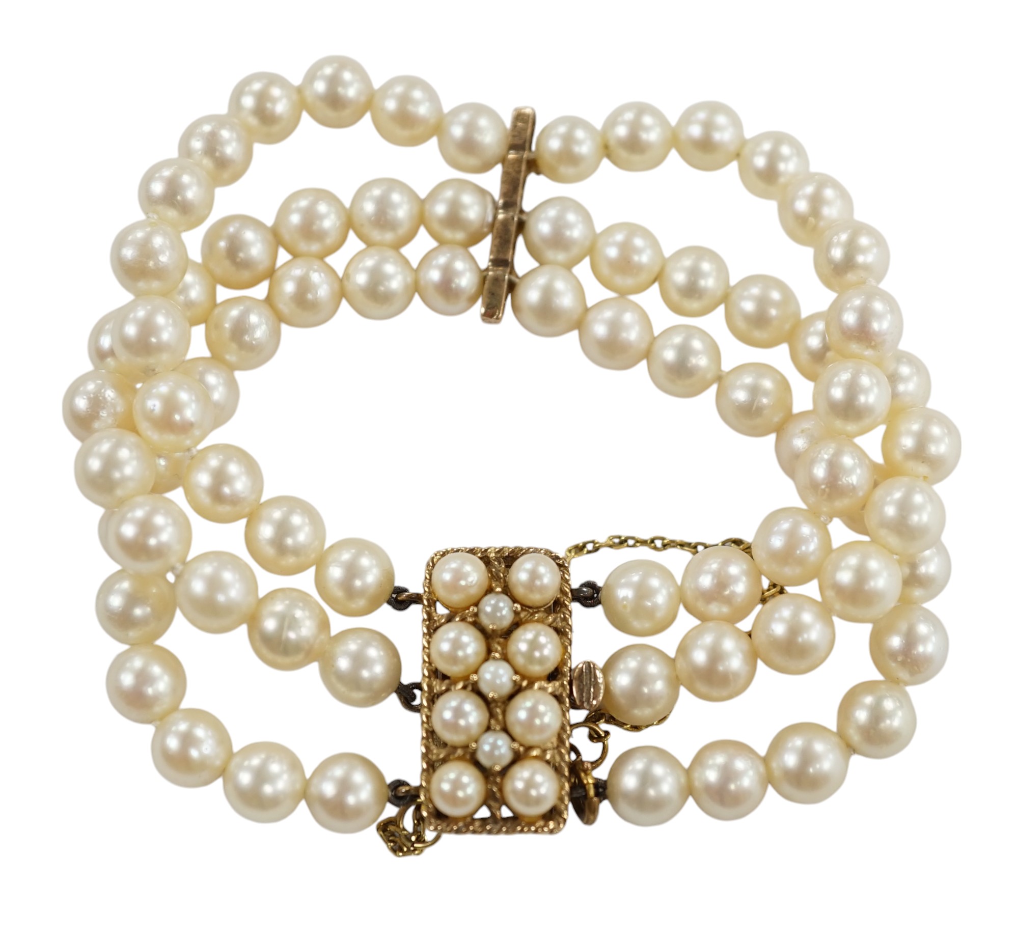 A triple strand cultured pearl necklace, with 9ct and cultured pearl clasp and spacer, 18cm. Condition - fair